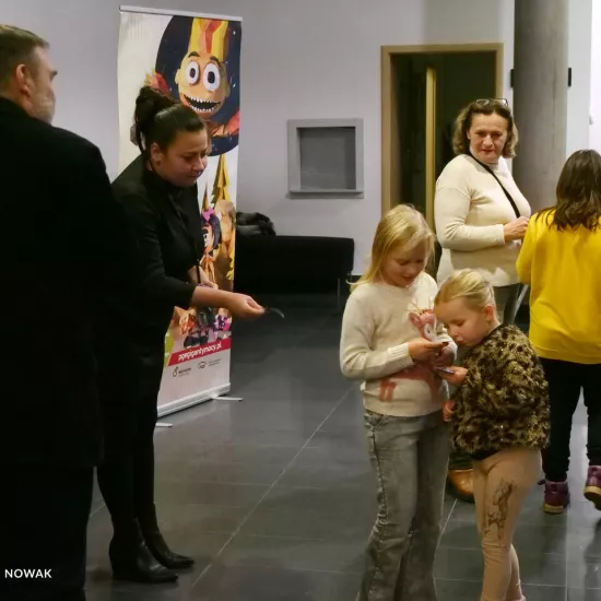 zdjęcie przedstawia widzów oczekujących na wejście na salę teatralną, na foyer w Miejskim Centrum Kultury w Bełchatowie 