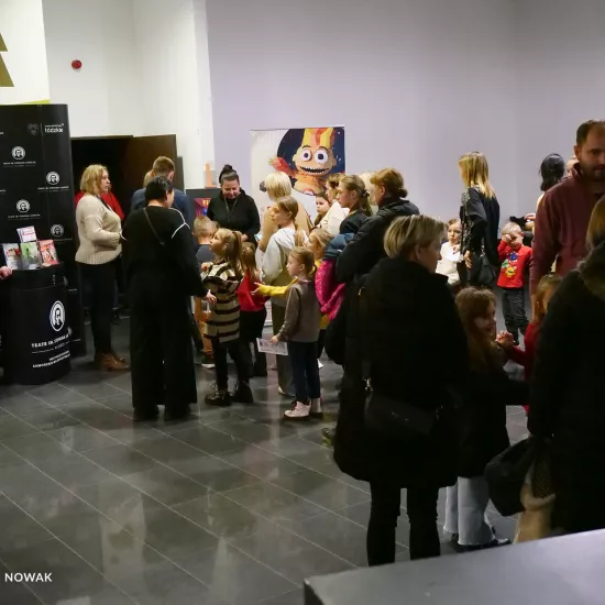 zdjęcie przedstawia widzów oczekujących na wejście na salę teatralną, na foyer w Miejskim Centrum Kultury w Bełchatowie 