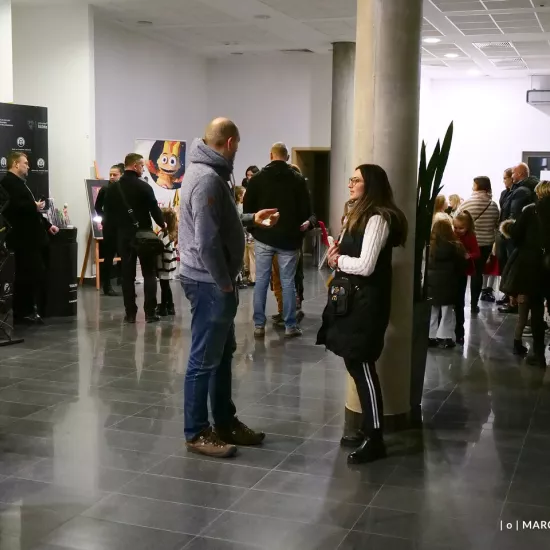 zdjęcie przedstawia widzów oczekujących na wejście na salę teatralną, na foyer w Miejskim Centrum Kultury w Bełchatowie 