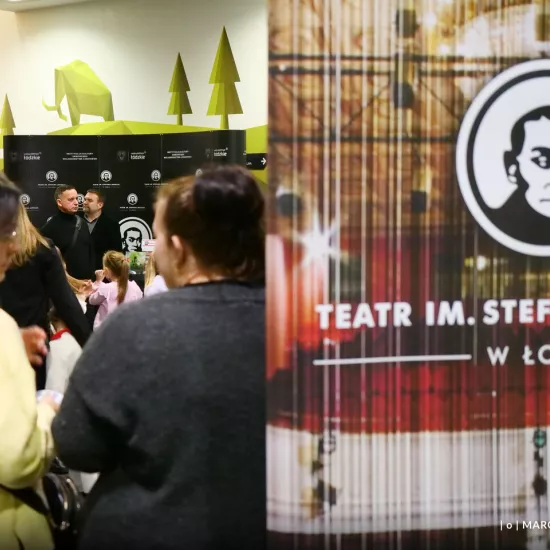 zdjęcie przedstawia widzów oczekujących na wejście na salę teatralną, na foyer w Miejskim Centrum Kultury w Bełchatowie 