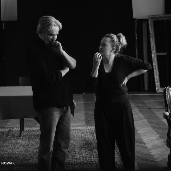 zdjęcie przedstawia próbę spektaklu „Świętoszek" w reżyserii Magdaleny Piekorz. Na zdjęciu dwoje aktorów: Dariusz Bereski, który wygląda na zamyślonego oraz Iwona Karlicka, która lewą ręką się podpiera a prawą gestykuluje, jakby tłumaczyła coś aktorowi. 