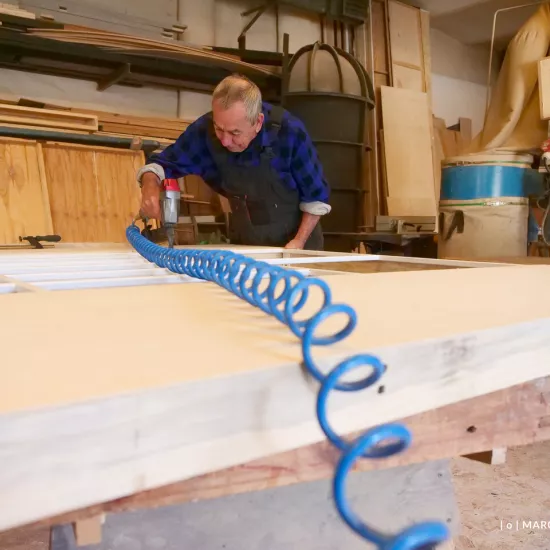 przygotowania do premiery „Świętoszka", stolarnia. Pracownik na zdjęciu przycina drewniane elementy scenografii, fot. Marcin Nowak