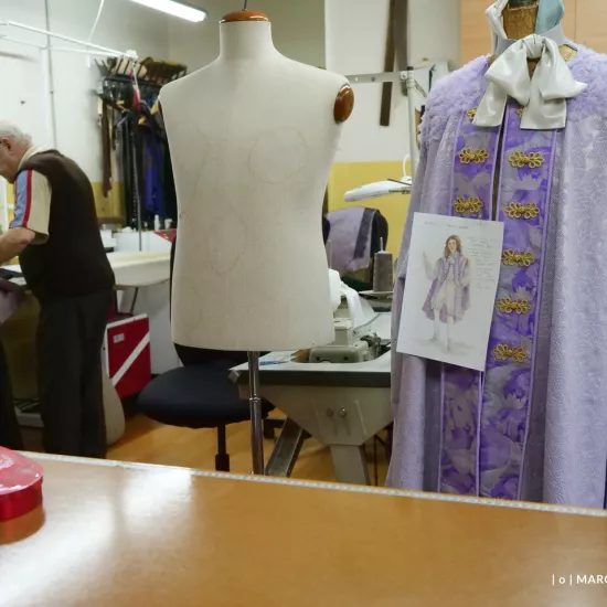 przygotowania do premiery „Świętoszka", pracownia krawiecka. Na pierwszym planie widać manekiny, na jednym z nich wisi gotowy kostium, a na nim przyczepiona kartka z projektem kostiumu. W tle widać pracownika, który pracuje nad kolejnym kostiumem. fot. Marcin Nowak