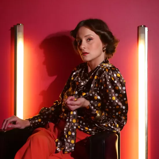 sesja zdjęciowa do spektaklu, na zdjęciu: Natalia Klepacka, która siedzi między dwiema zapalonymi lampami led, fot. Marcin Nowak