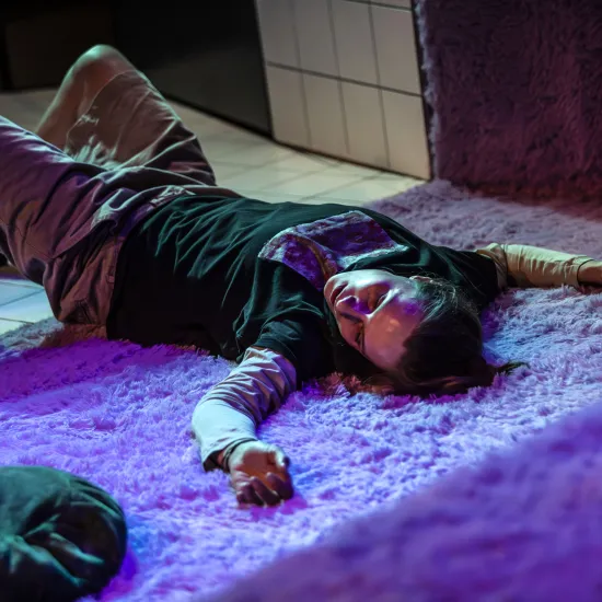 Zdjęcie ze spektaklu „Czas na wielki numer". Na fotografii aktorka Natalia Klepacka. Aktorka leży na plecach na różowym, puchatym dywanie. Nogi ma zgięte w kolanach, ręce nad głową rozłożone szeroko. Autorką zdjęcia jest Natalia Kabanow. 