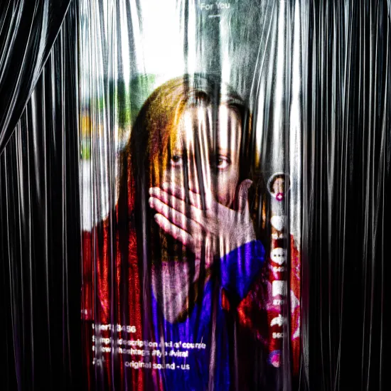 Zdjęcie ze spektaklu „Czas na wielki numer". Na fotografii widać projekcję, która wygląda jak rolka na mediach społecznościowych. Na wideo jest kobieta, która zakrywa ręką usta